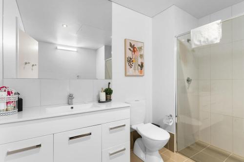 ein weißes Bad mit einem WC und einer Dusche in der Unterkunft 1BR Adelaide CBD Apt The Best Location in Adelaide