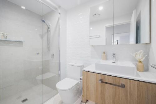 a bathroom with a toilet and a sink and a shower at Surf's Up Stunning Paradise Apartment Serenity in Gold Coast