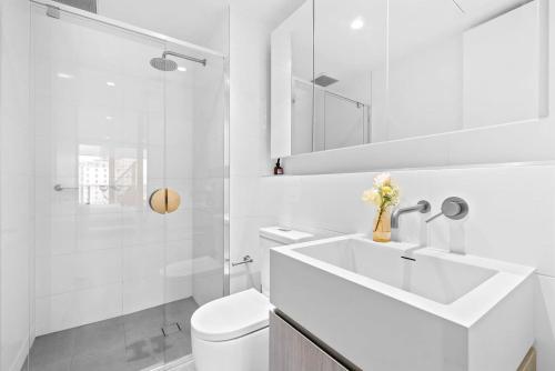 y baño blanco con lavabo y ducha. en Adelaide CBD Oasis - 2BR Realm Retreat - Level 19 en Adelaida