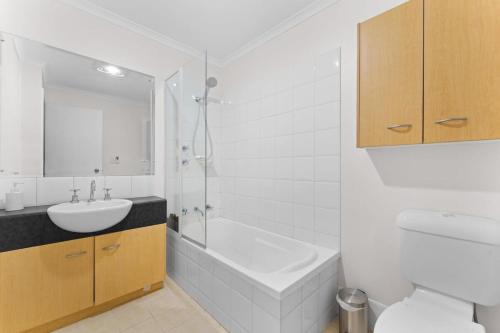 a bathroom with a tub and a sink and a toilet at Family friendly CBD 3BR Apt Hurtle Square in Adelaide
