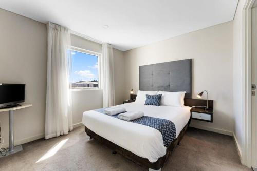 - une chambre avec un grand lit et une grande fenêtre dans l'établissement CBD 2BR Apartment at 96 North Tce - Free Parking, à Adélaïde