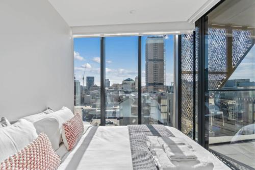 a bedroom with a large window with a view of a city at Vivid on Realm RundleMall-Gym-EasyLifestyle in Adelaide