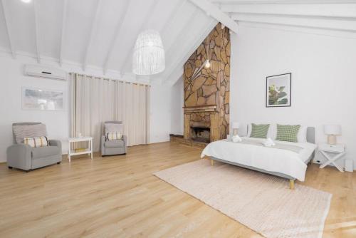 - une chambre blanche avec un lit et une cheminée dans l'établissement The 2BR Farm Escape idyllic scenery peaceful tour, à Gold Coast