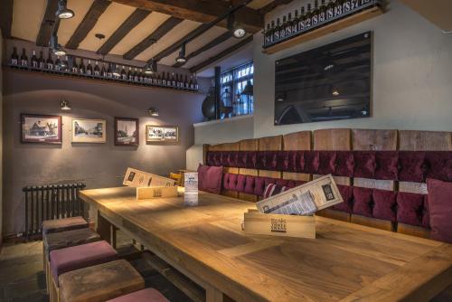 a restaurant with a long wooden table and chairs at The Three Swans Hotel, Market Harborough, Leicestershire - The Coaching Inn Group in Market Harborough