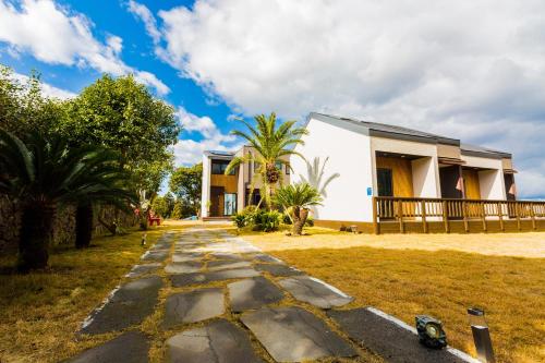 a house with a stone path in front of it at Jeju batdol guesthouse in Jeju