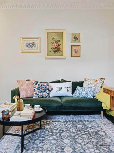 a living room with a green couch and a table at XQ Collection Jaques la Maison in Sydney