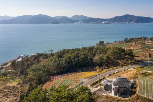 a house on a hill next to the water at beotkkotgil jinaseo in Namhae