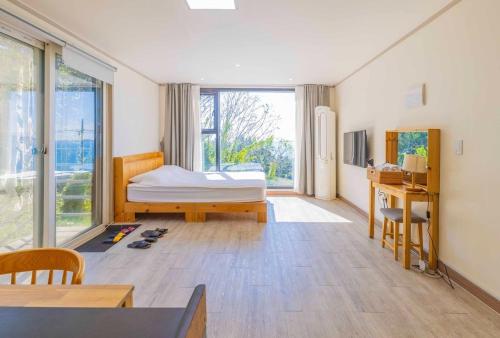 a bedroom with a bed and a desk and a window at beotkkotgil jinaseo in Namhae