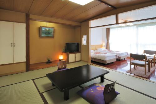 - un salon avec une chambre dotée d'un lit et d'une table dans l'établissement Yuzawa Grand Hotel, à Yuzawa