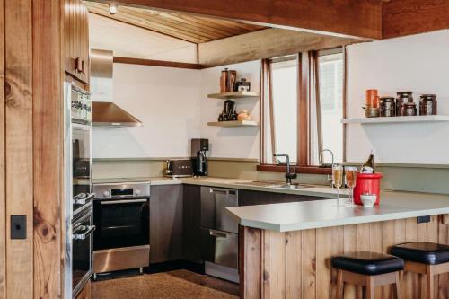 a kitchen with wooden cabinets and a counter top at The Sundowner, 25 Lentara St - luxury pet friendly retreat with pool in Fingal Bay