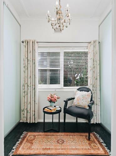 a chair and a table in a room with a window at XQ Collection Jaques la Maison in Sydney