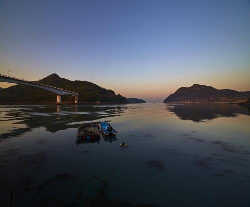 two boats in the water next to a bridge at Goheung hayan noeul hotel in Goheung