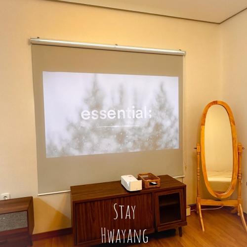 a projection screen in a room with a table and a mirror at Damyang Hwayang in Damyang