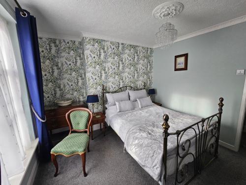 a bedroom with a bed and a chair and a desk at Mostyn House in Llandudno