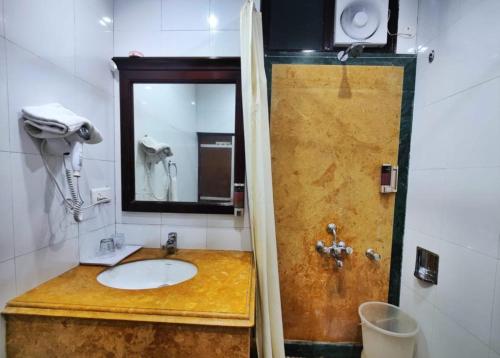 y baño con lavabo y espejo. en Hotel Marc Mall Road Shimla - Family Friendly & Parking - A Four Star Luxury Hotel Mountain View, en Shimla