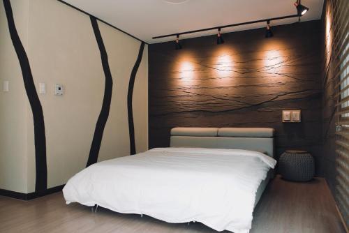 a bedroom with a bed with a wooden wall at Byeoldeul-ui Gichim Pension in Inje