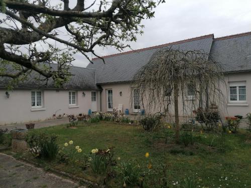 un jardín frente a una casa blanca en Le Clos des Roses, en Civray-de-Touraine