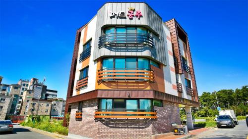 a tall building with a sign on the side of it at Daecheon Mud Gongju Pension in Boryeong