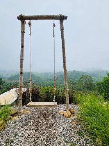 a swing on a hill with a view at Camping phutajoy Khaosok แคมป์ปิ้งภูตาจ้อยเขาศก in Ban Thung Lang Tham