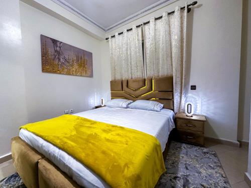a bedroom with a large bed with a yellow blanket at LovelyStay - Luxury & proximity to Corniche and TGV in Tangier