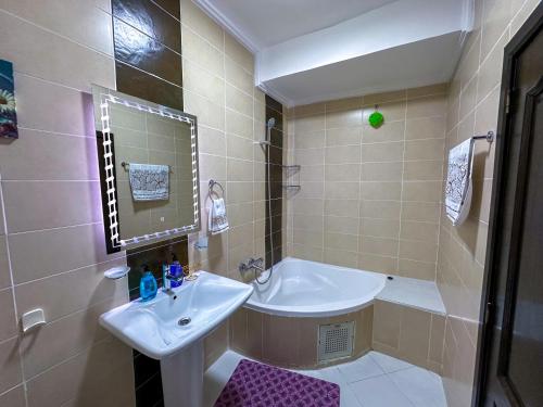 a bathroom with a sink and a bath tub and a sink at LovelyStay - Luxury & proximity to Corniche and TGV in Tangier