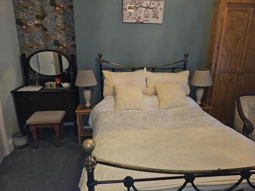 a bedroom with a large bed and a mirror at Mostyn House in Llandudno