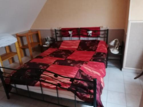 Le Clos des Roses في Civray-de-Touraine: غرفة نوم بسرير وبطانية حمراء