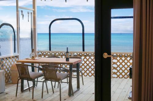 a table and chairs on a balcony with a view of the ocean at Taean Stay The Delight Pension in Taean