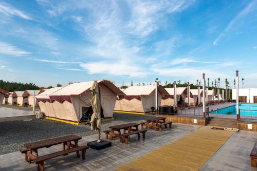 a row of tents with benches and a pool at Yeongcheon Auno feliz in Yeongcheon