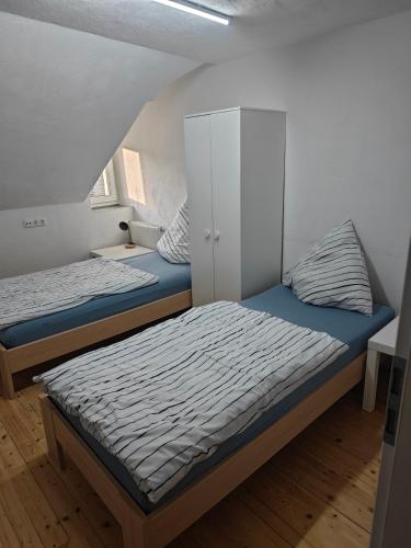 a bedroom with two beds and a white cabinet at Work and Stay Dürwiß IaM Neu Modernisiert in Eschweiler