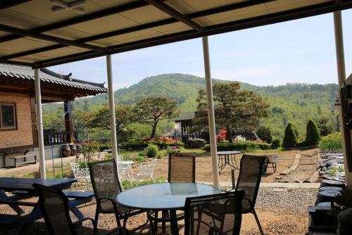 a table and chairs on a patio with a view of a mountain at Yangpyeong Daon Pension in Yangpyeong