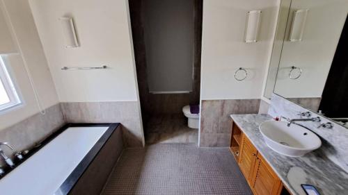 a bathroom with a tub and a sink and a toilet at Hua Hin Blue Lagoon in Cha Am