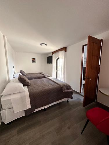 um quarto com uma cama grande e uma cadeira vermelha em Hotel Terravolcan em La Tenería