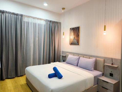 a bedroom with a large bed with a blue object on it at Country Garden J Agape Homestay JB COZY 1006-4A in Johor Bahru
