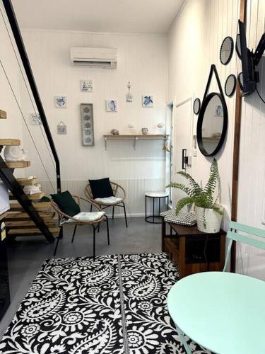 a room with chairs and a table and a mirror at NEW! Sea Joley Tiny Home in Nelly Bay