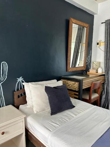 a bedroom with a bed with a mirror and a table at The VRNON Boutique by MY hostel in Boracay