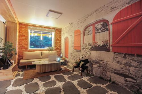 a living room with a couch and a dog in it at Camel Pension in Pocheon in Pocheon