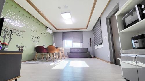 a living room with a blue couch and chairs at Goseong Deulggot Stay Private House in Goseong