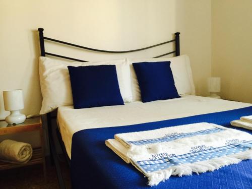 ローマにあるThe 7th Floor in Romeのベッド(青と白のシーツ、青の枕付)