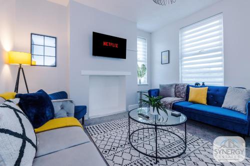 uma sala de estar com um sofá azul e uma mesa em Sapphire House, Manchester - by Synergy Estates em Manchester