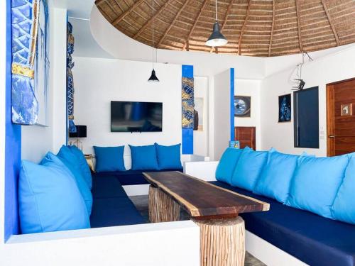 a living room with a blue couch and a wooden table at Magritte - Balinese Style Cosy Villa in Amphoe Koksamui