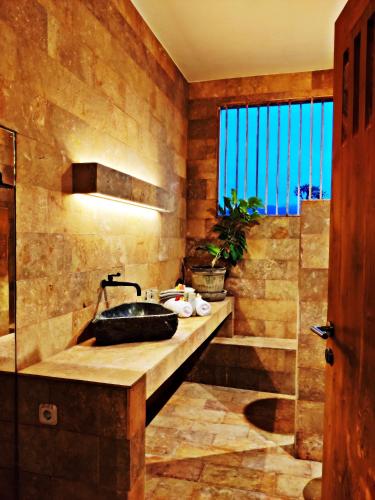 a bathroom with a sink and a large window at JOGLO APONG Beachfront Apartment in Tegallengah