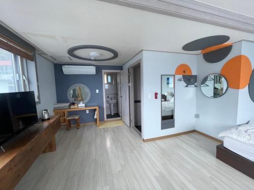 Una sala de estar con un televisor de pantalla plana en una pared. en Ulleungdo JD Hostel, en Ullŭng