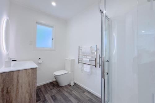 a bathroom with a toilet and a sink and a shower at Peaceful Home in the Prime Greenlane in Auckland