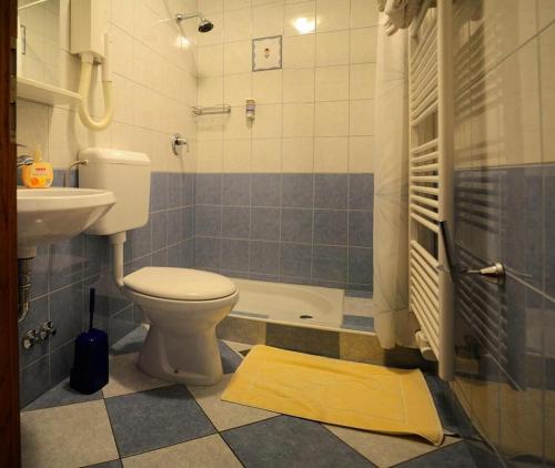 a bathroom with a toilet and a sink and a tub at Bed and Breakfast Valjavec in Kranj