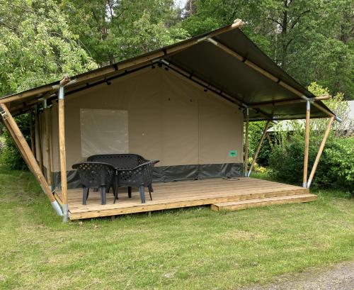 a tent with a table and chairs on a deck at Safaritent voor 4 personen in Zwiggelte