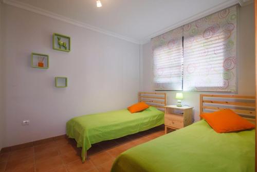 アデへにあるApartment Playa Paraisoの窓付きの客室で、緑色のベッド2台が備わります。