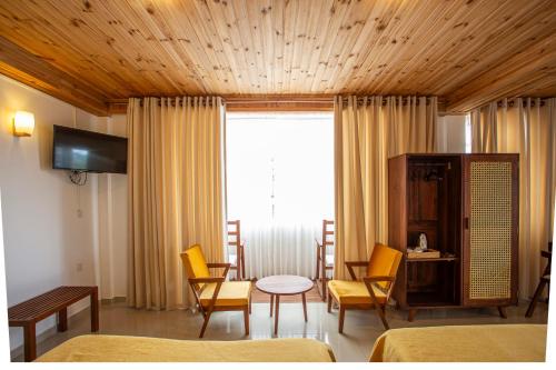 a hotel room with a table and chairs and a window at Country Club Nuwara Eliya in Nuwara Eliya