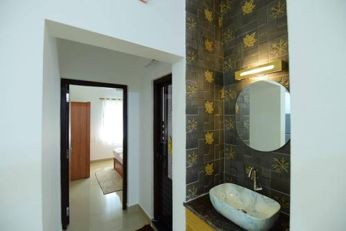W łazience znajduje się umywalka i lustro. w obiekcie Lourels Stay w mieście Udupi