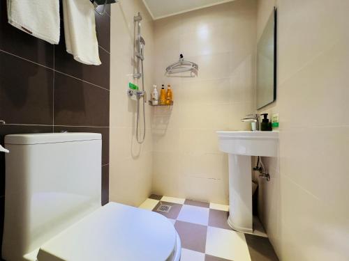 ein Bad mit einem WC und einem Waschbecken in der Unterkunft Beijing Dongdan Hotel in Peking